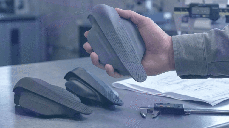 Hand holding one of three drones using IA3D's Rapid Prototyping service, two others visible on table