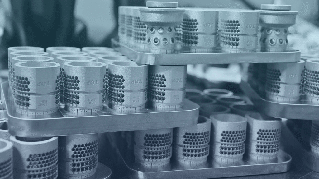 Bridge manufacturing metal production parts by IA3D. (Dozens of 3D-Printed metal muzzle breaks.)