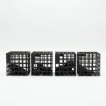 Picture of four of IA3D's unique "Cages." Plastic boxes with 3D printed parts printed directly inside them, so they don't get lost in the manufacturing process.