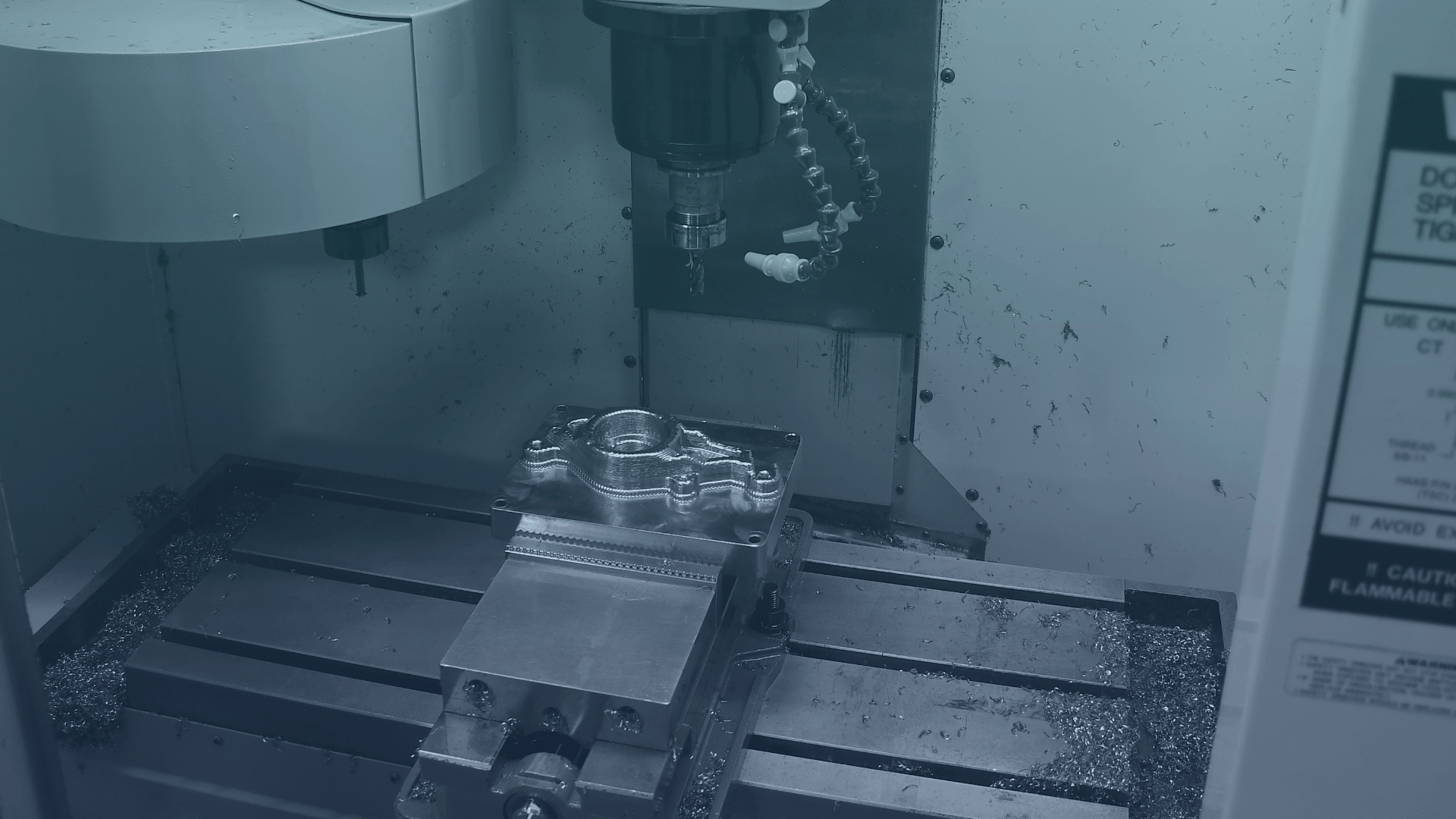Advanced Manufacturing, 3D Printed metal part on one of IA3D's 3-axis mills. Drill bit and metal shavings visible.